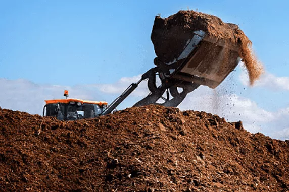 mulch in a pile being moved by heavy machinery